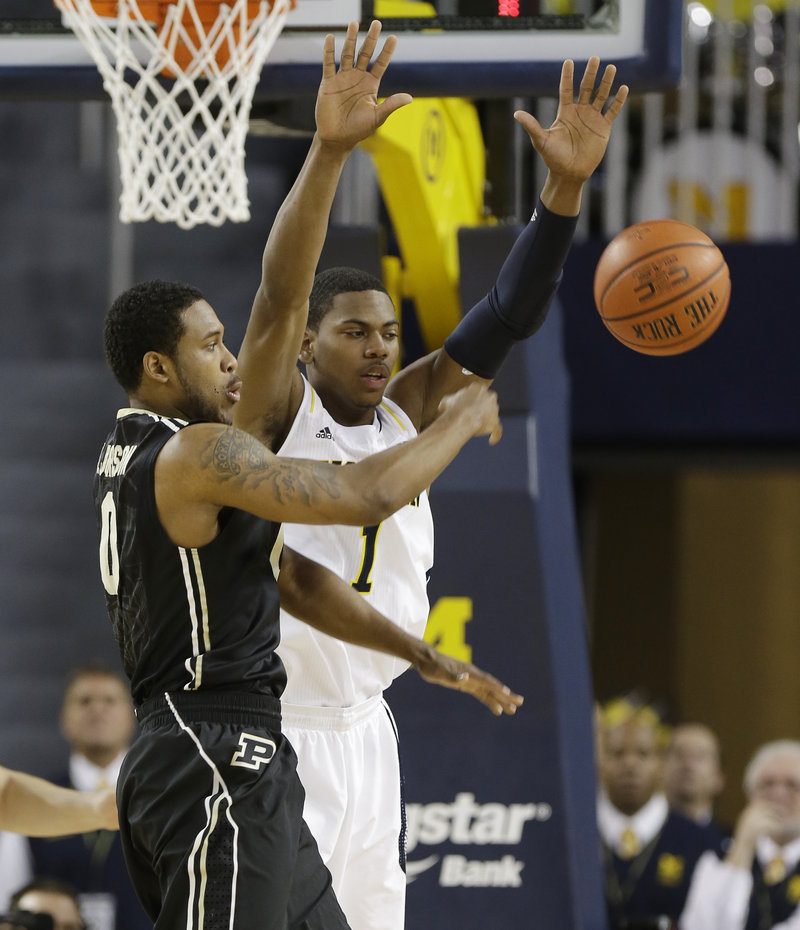 Terone Johnson of Purdue, left, passes the ball Thursday night while guarded by Glenn Robinson III of second-ranked Michigan during Michigan’s 68-53 victory.