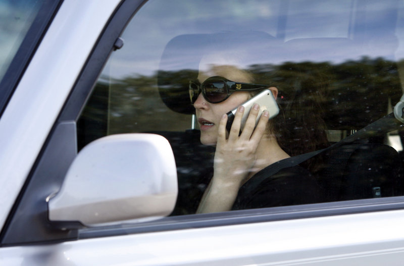 A motorist uses a cellphone while driving on I-295 in Portland. A recent survey shows a “do as I say, not as I do” attitude when it comes to cellphone use by drivers.