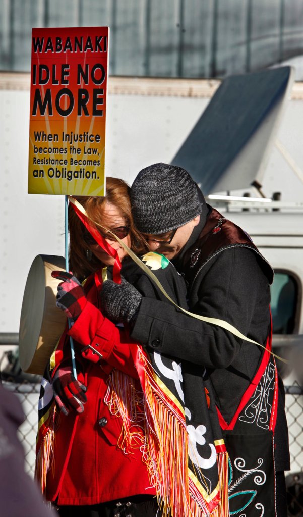 Donna Brown, left, and her husband, Jason, huddle against the wind while listening to speakers at the anti-tar sands rally Saturday.
