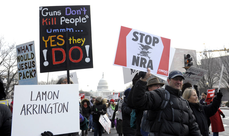 Marchers supporting gun control walk from the U.S. Capitol down the Mall in Washington on Saturday. Some signs, like the one at lower left, bore names of victims of gun violence.