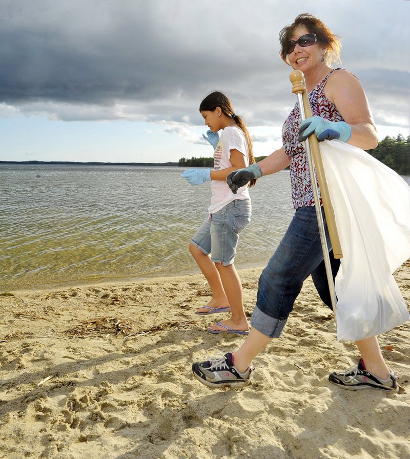 Joanne Alfiero and her daughter Grace pick up trash on Raymond Beach last May, when Alfiero was the beach manager. She says the town needs a full-time manager in summer, which she is unable to do.