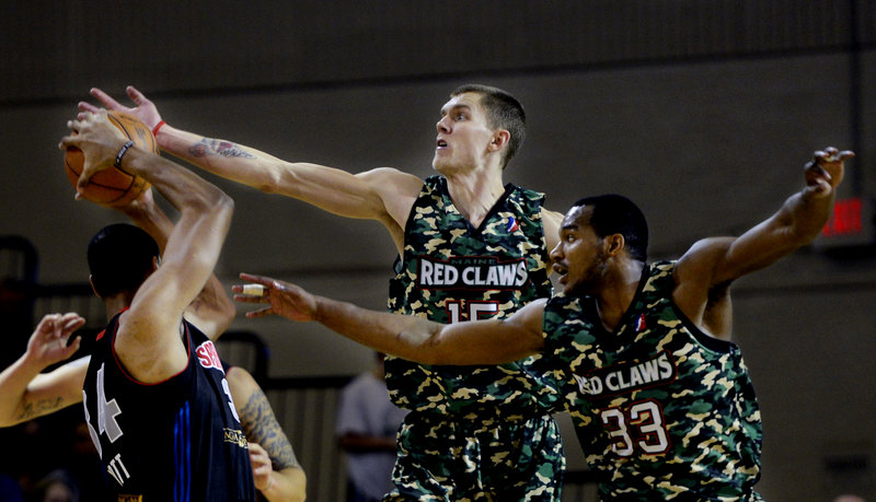 Micah Downs, center, and Chris Wright of the Red Claws play tight defense against Springfield’s Carleton Scott during Maine’s 120-112 win Sunday at the Portland Expo. The Red Claws wore special uniforms for Military Appreciation Day.