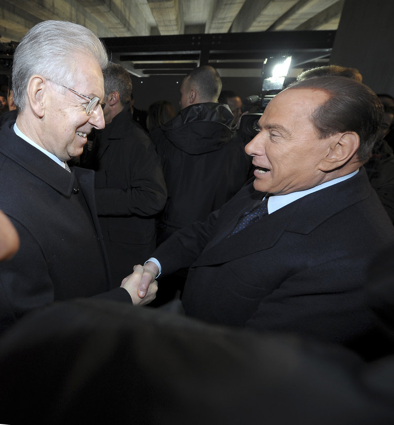Italian Premier Mario Monti, left, and former Premier Silvio Berlusconi meet in Milan, Italy, on Sunday. Berlusconi spoke in defense of Benito Mussolini for allying himself with Hitler.