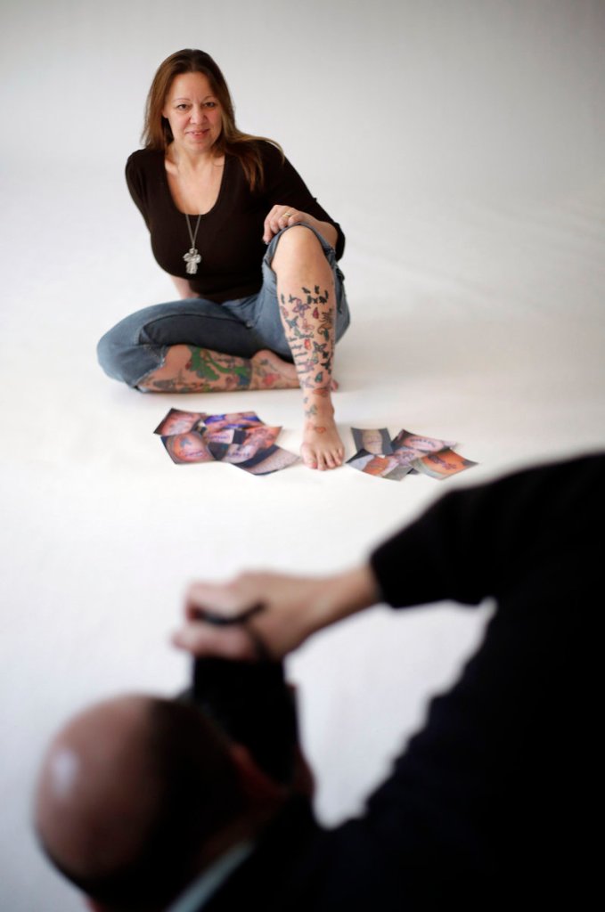 John Pitocco takes photographs of Christine Jones, a survivor of the 2003 Station nightclub fire in West Warwick, R.I. The images will be displayed in an exhibit to honor those killed or injured in the blaze. Jones has 100 butterfly tattoos on her legs to honor the 100 who died.