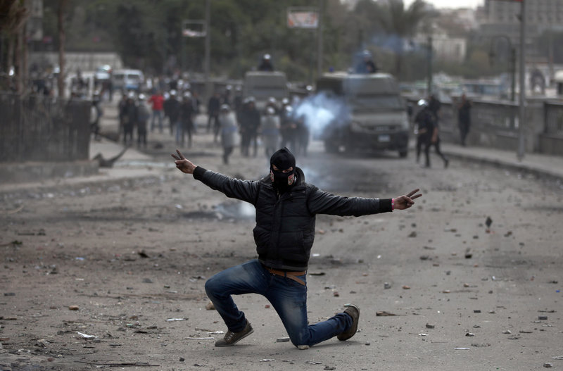 An Egyptian protester, part of the Black Bloc, flashes the victory sign during clashes with police in Cairo on Monday.