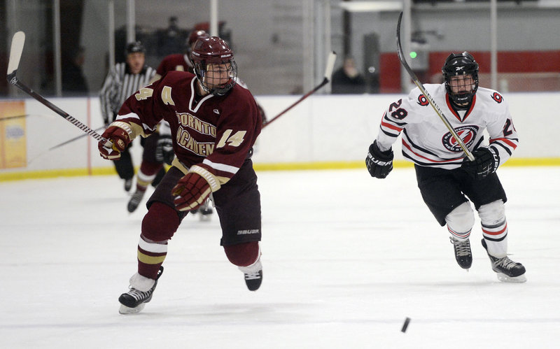 Thornton Academy’s Drew Lavigne, left, looks for the fast-approaching Jacob Gross of Scarborough, as the two race for the puck during Scarborough’s 4-3 win Monday afternoon at the MHG Ice Centre in Saco.