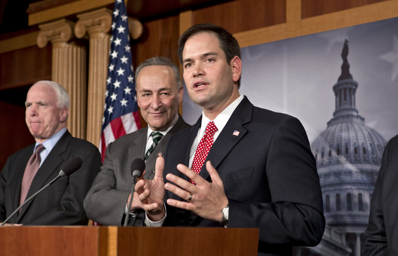 Sen. Marco Rubio, R-Fla., right, answers a reporter’s question as a bipartisan group of senators propose a sweeping reform of the nation’s immigration laws on Monday. With him at the Capitol in Washington are, from left, Sen. John McCain, R-Ariz., and Sen. Charles Schumer, D-N.Y.
