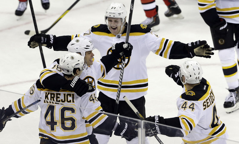 Boston’s David Krejci gets a hug from Nathan Horton as Dougie Hamilton approaches after he assisted on Krejci’s game-winning goal in Boston’s 5-3 win over Carolina.