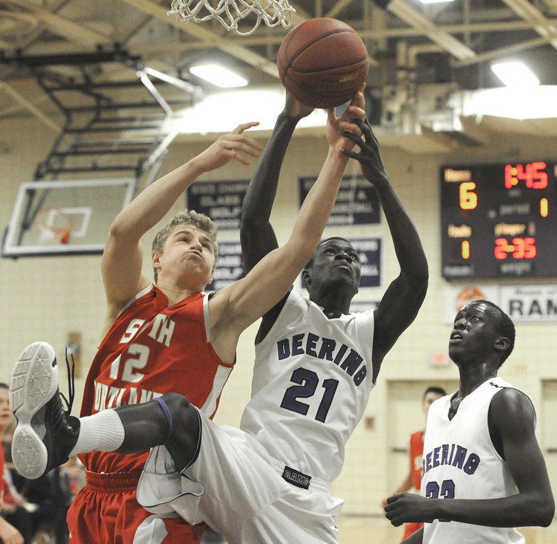 Ahmed Ismail Ahmed of Deering, center, attempts to keep a rebound from Ben Burkey of South Portland during the first quarter of their SMAA game Tuesday night. South Portland won, 53-38.