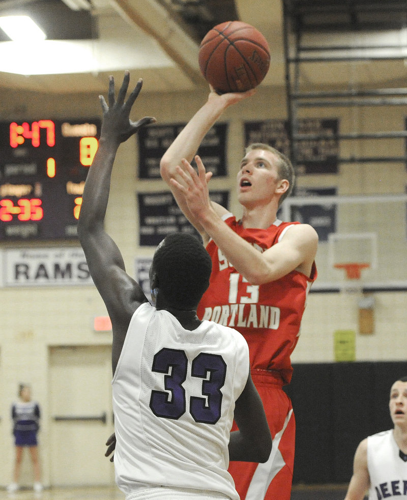 Tanner Hyland, who scored a game-high 22 points for South Portland, finds room to loft a shot over Labson Abwoch of Deering.