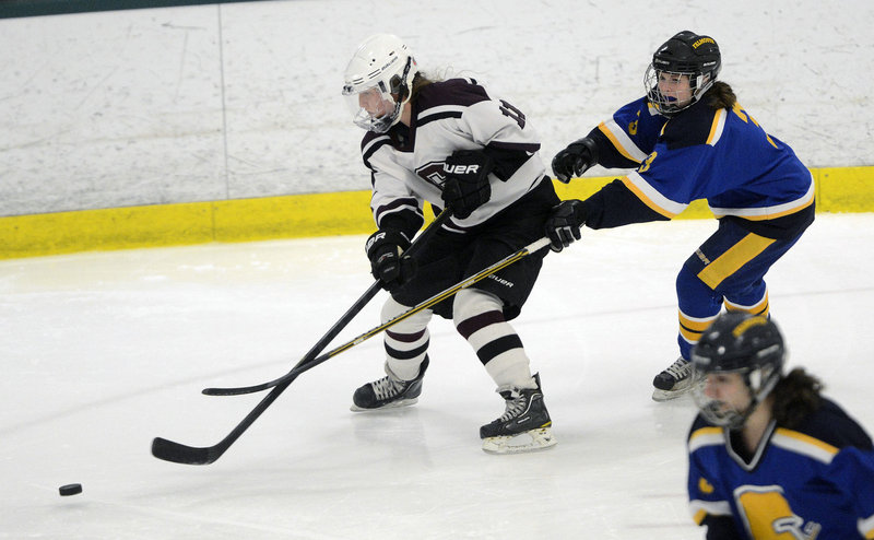 Mary Morrison of Greely goes after the puck Wednesday night while being chased by Abby Payson of Falmouth. Greely won, 5-1.