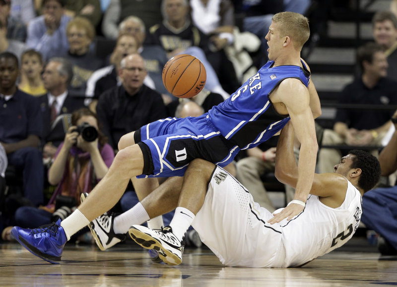 Mason Plumlee of Duke falls on top of Wake Forest’s Devin Thomas in Wednesday’s game at Winston-Salem, N.C. Plumlee had 32 points in Duke’s 75-70 win.
