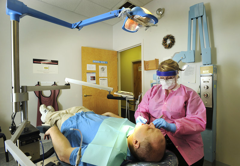 On Thursday, dental hygienist Torey Richard cleans the teeth of patient Rick Hagan, 45, of Bath, who has bipolar disorder, at the state-funded dental clinic on Preble Street in Portland.
