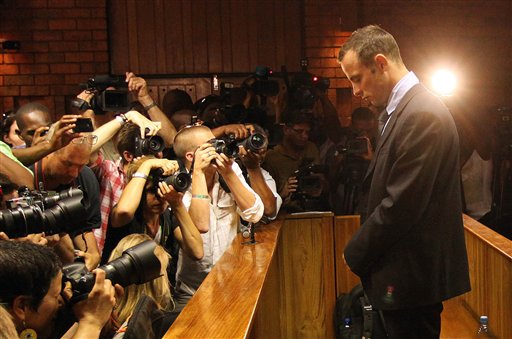 Photographers take photos of Olympic athlete Oscar Pistorius as he stands in the dock during his bail hearing at the magistrates court in Pretoria, South Africa, Friday, Feb. 22, 2013. The fourth and likely final day of Oscar Pistorius' bail hearing opened on Friday, with the magistrate then to rule if the double-amputee athlete can be freed before trial or if he has to remain in custody over the shooting death of his girlfriend. (AP Photo/Themba Hadebe)