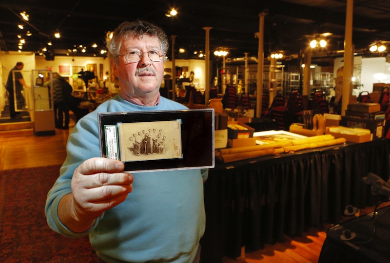 Floyd Hartford, owner of the Saco River Auction Co., holds an 1865 card of the Brooklyn Atlantics baseball team. The card will be auctioned on Wednesday, Feb. 6, 2013.
