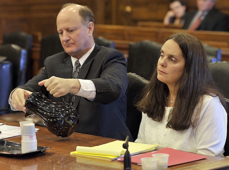 William Childs, attorney for Paula Spencer, pours a glass of water as she listens to the judge give instructions to the attorneys before opening arguments.