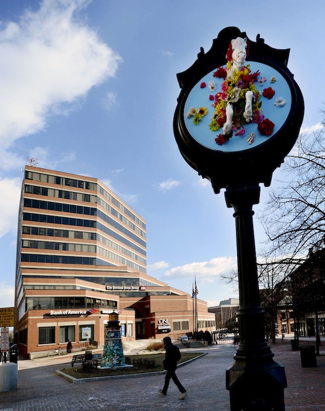 The old-fashioned clock in Monument Square in Portland stands with One City Center in the background.
