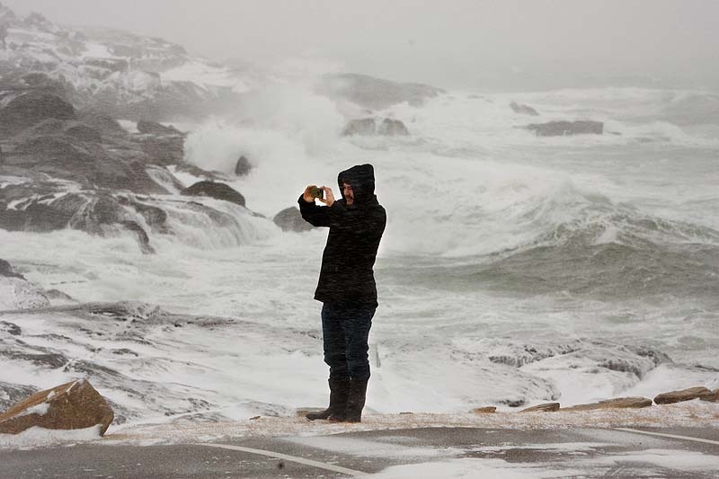 Dillon Johnson shoots a video of the turbulent surf at Nubble Light in Cape Neddick on Friday Feb. 08, 2013, as a blizzard begins to blanket Maine with several feet of snow.