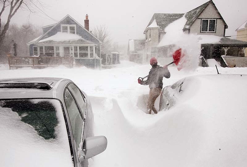 Julia May digs buried cars from the snow in her driveway on West Grand Avenue in Ocean Park on Saturday.
