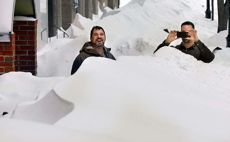 Adrian Gusteau, left, chef at the Old Port Tavern, and Jason Bisbing, right, bartender, step outside to marvel at the mounds of snow on the sidewalks of Moulton Street on Saturday afternoon in the aftermath of a blizzard that dumped more than 30 inches of snow on downtown Portland.