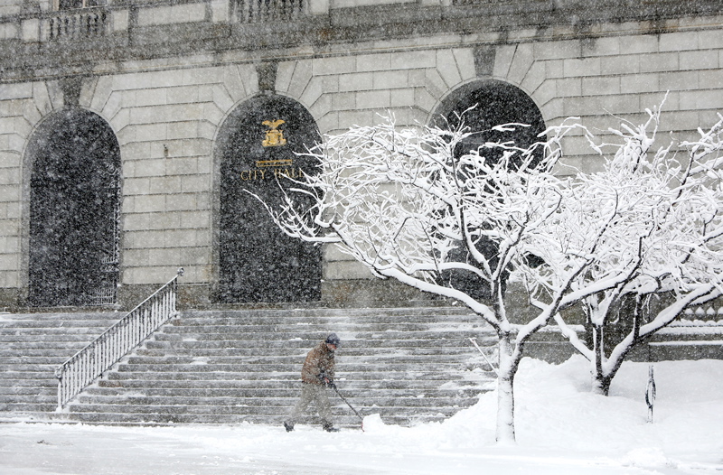 Pat Farrell, an employee of the Portland Recreation and Facilities Department, shovels the front of City Hall during the heavy snow Sunday in Portland. By noon Farrell and his co-workers had shoveled at City Hall four times.