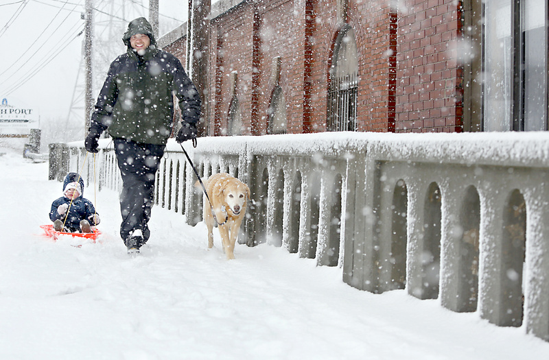 Chris Kessler of South Portland pulls his son Cadence, with his dog Abby, after sledding at Thomas Knight Park in South Portland during the heavy snowfall Sunday morning.