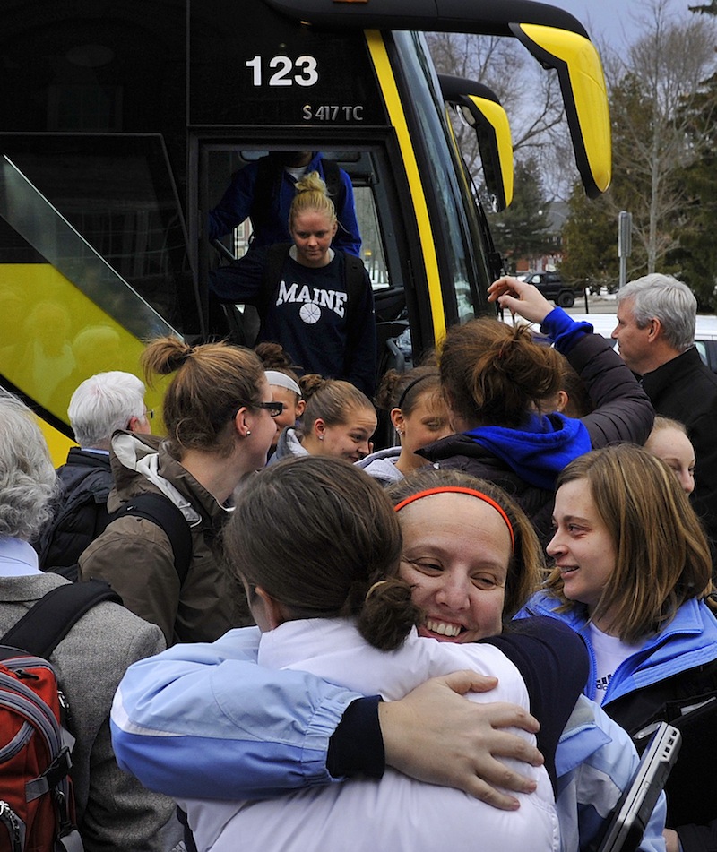 Assistant coach Amy Vachon receives a hug from former director of basketball operations Tracey Guerrette as the University of Maine women's basketball team returned to Orono on Wednesday evening, Feb. 27, 2013, after being involved in a harrowing crash on I-95 in Massachusetts on Tuesday night.