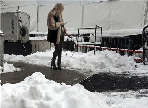 A woman checks her mobile phone outside Lincoln Center, home of New York's Fashion Week shows, Saturday, Feb. 9, 2013. In New York City, the snow total in Central Park was 8.1 inches by 3 a.m. (AP Photo/Richard Drew)