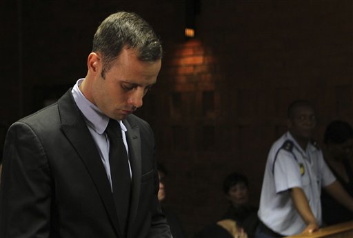 Olympic athlete Oscar Pistorius stands inside the court as a police officer looks on during his bail hearing at the magistrate court in Pretoria, South Africa, on Wednesday. A South African judge says defense lawyers will need to offer "exceptional" reasons to convince him to grant bail for Pistorius.