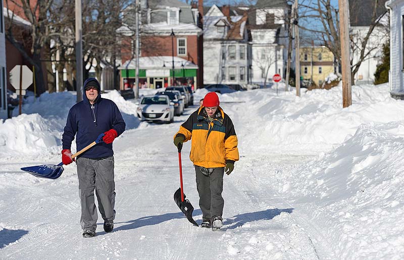 Chris Dyer, left, and Michael Demers of Saco make their way down School Street with shovels in hand as they look for driveways to shovel Sunday.
