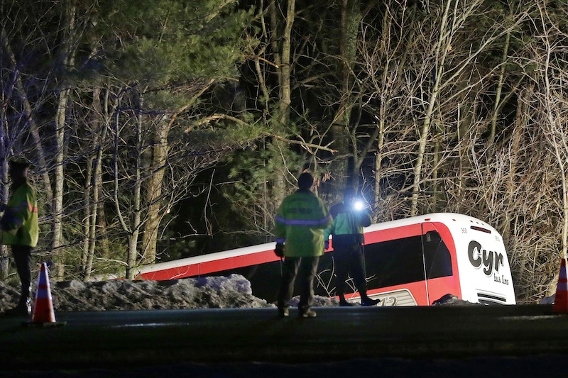 Police work at the scene of the bus crash in Georgetown, Mass., on Tuesday that injured the bus driver and seven players and two coaches from the University of Maine women's basketball team.