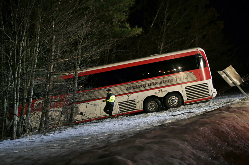 Police work at the scene in Georgetown, Mass., on Tuesday where a bus carrying University of Maine women's basketball players crashed on Interstate 95 north of Boston.