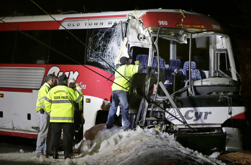 Massachusetts State Police examine the front of a bus that crashed in Georgetown, Mass., on Tuesday while carrying University of Maine women's basketball players to a game.