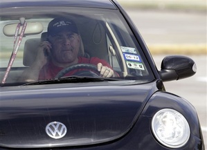 A driver uses a cellphone while driving Wednesday, Dec. 14, 2011, in Houston. A Maine legislative committee voted 10-1 on Tuesday against a bill that would ban most motorists from using handheld cellphones. (AP Photo/David J. Phillip)