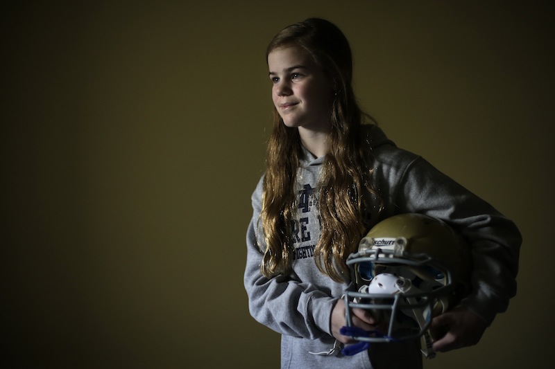 Caroline Pla, 11, poses for a photograph with her helmet Thursday, Feb. 21, 2013, in Doylestown, Pa. Pla is fighting the Roman Catholic Archdiocese of Philadelphia for the right to continue playing church sponsored youth football. (AP Photo/Matt Rourke)