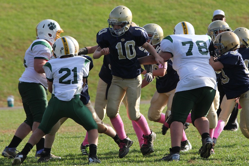 In this 2012 photo provided by Marycecelia Pla, her daughter, Caroline Pla (10), center, plays in a Catholic Youth Organization league football game. The 11-year-old girl who's been playing football since kindergarten wants Philadelphia's Roman Catholic archdiocese to overturn a boys-only rule. (AP Photo/Pla Family)