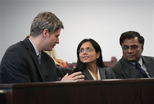 Former state lab chemist Annie Dookhan, center, speaks with her lawyer Nick Gordon, left, at Middlesex Superior Court as she waits for her for arraignment to begin with her father, Rasheed Khan, on Jan. 9, 2013, in Woburn, Mass. She is charged in connection with altering drug evidence during the testing process and obstructing justice.