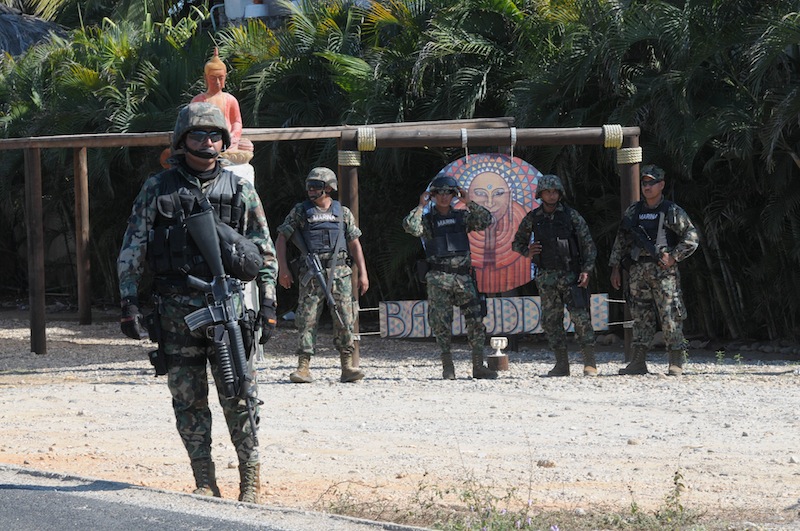 Mexican navy marines stand at a roadblock due to stepped up security after masked armed men broke into a beach home, raping six Spanish tourists who had rented the house in Acapulco, Mexico, Tuesday Feb. 5, 2013. According to the Mayor of Acapulco, five masked men burst into a house the Spaniards had rented on the outskirts of Acapulco, in a low-key area near the beach, and held a group of six Spanish men and one Mexican woman at gunpoint, while they raped the Spanish women before dawn on Monday. (AP Photo/Bernandino Hernandez)
