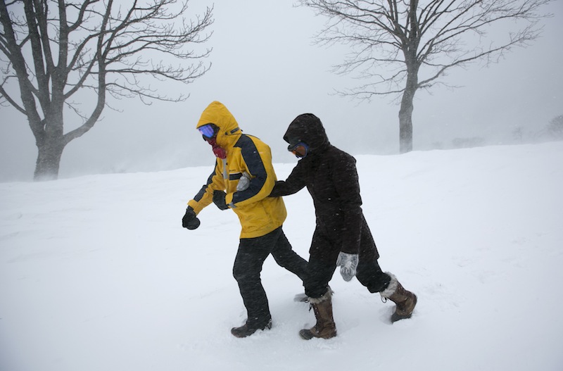Alexandria Brahler, right, holds onto Colin Matthews, as they struggle against strong winds and blowing snow Saturday, Feb. 9, 2013 in Portland, Maine. Officials are cautioning residents to stay off the roads in Maine, where Portland set an all-time snowfall record and blowing snow continues to reduce visibility on the coast. (AP Photo/Robert F. Bukaty)