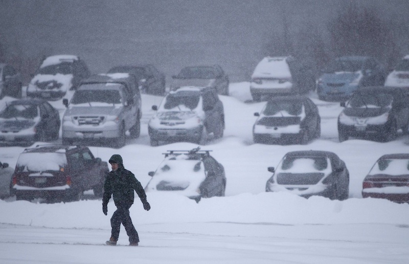 A man battles fierce winds as he climbs a hill after leaving his car in a parking lot to avoid being towed during a parking ban, Friday, Feb. 8, 2013, in Portland, Maine. (AP Photo/Robert F. Bukaty)