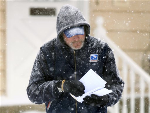 In this Saturday Dec. 19, 2009 file photo, U. S. Post Office letter carrier Tim Bell delivers the mail during a snow storm in Havertown, Pa. The financially struggling U.S. Postal Service says it will stop delivering mail on Saturdays but continue to deliver packages six days a week under a plan aimed at saving about $2 billion a year. In an announcement scheduled for later Wednesday Feb. 6, 2013, the service is expected to say the Saturday mail cutback would begin in August. (AP Photo/Jacqueline Larma)