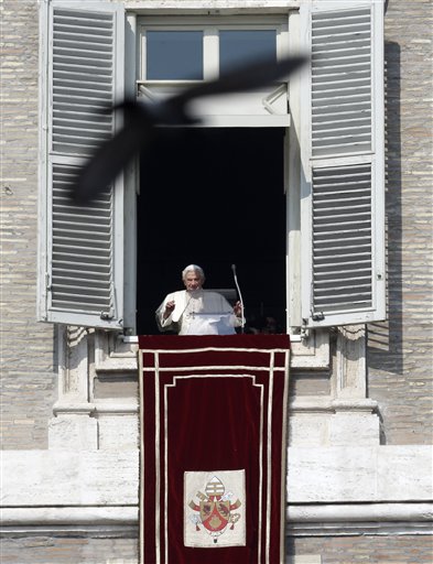 A pigeon flies in front of Pope Benedict XVI as he waves to the faithful during the Angelus noon prayer he celebrated from the window of his studio overlooking St. Peter's Square on Sunday.