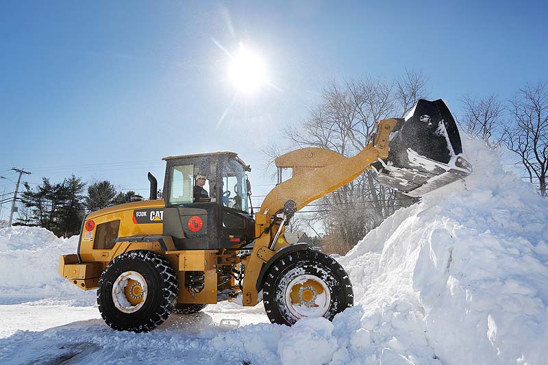 Chris Massey of Cornish operates a loader on Sunday at a shopping plaza in Falmouth, while removing snow for Shaw Brothers Construction.