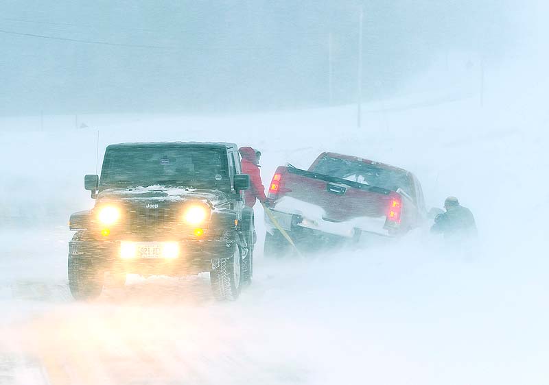 A motorist helps another getting back on the road as blizzard conditions make driving very dangerous along Route 114 in Gorham on Saturday.