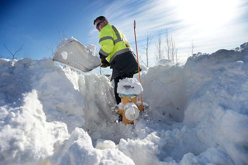 Portland firefighter Eric Weeks shovels out a fire hydrant on West Commercial Street in Portland on Sunday.