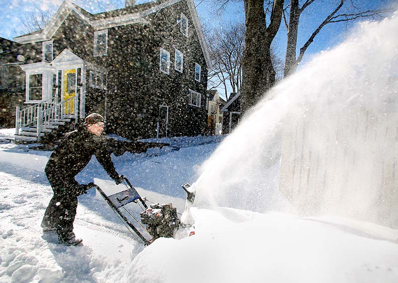 Mike Carey blows the snow off his driveway on Oakdale Street in Portland during the cleanup from a blizzard on Sunday.