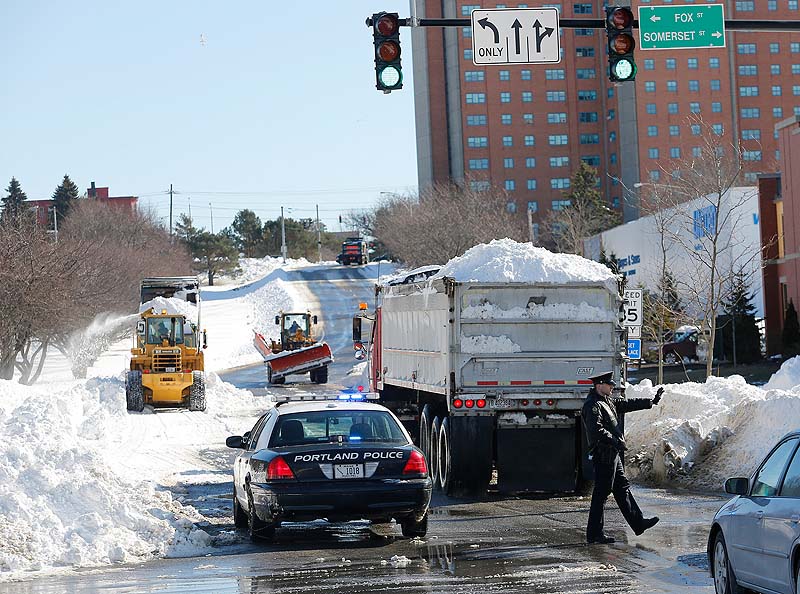 A section of Franklin Street in Portland is closed off Sunday as trucks bring in snow from around the city to be deposited in the median after a weekend storm brought 31.9 inches of snow to the city.