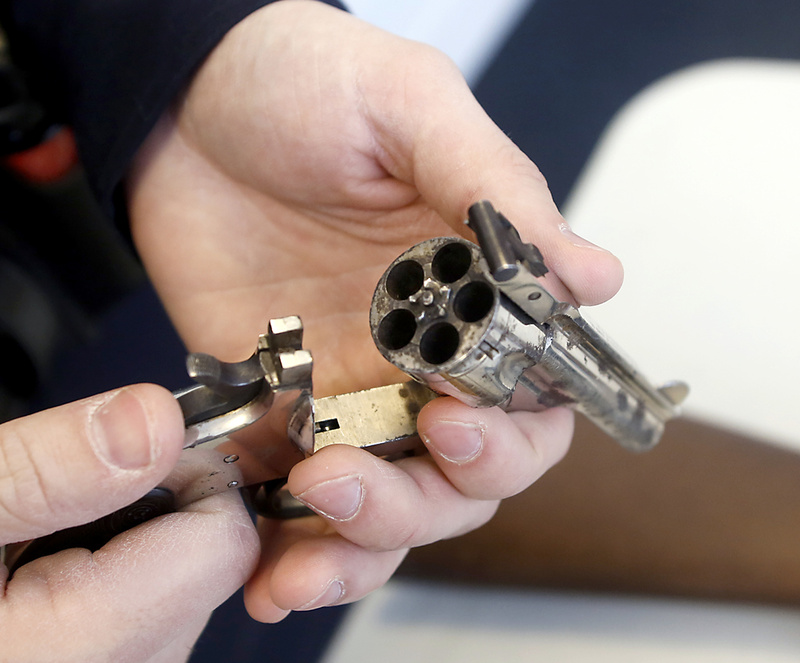 A Yarmouth police officer displays a .32-caliber revolver that was turned in to the department Saturday.