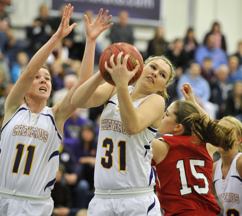 Cassidy Grover of Cheverus pulls in a rebound in front of teammate Mikayla Mayberry and Sanford's Shelby Paiement during their Western Class A girls' basketball quarterfinal at the Portland Expo. Cheverus won, 31-26.