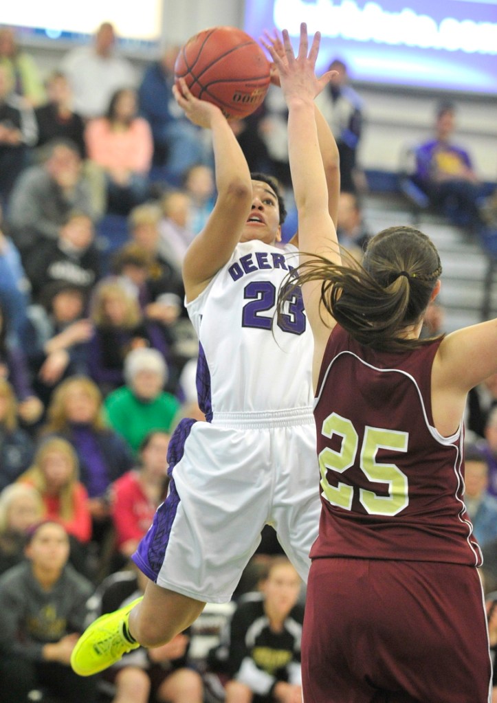 Keneisha DiRamio of Deering pulls up for a jumper over Thornton Academy's Olivia Shaw during their Western Class A quarterfinal Monday at the Portland Expo. Deering advanced with a 33-25 win.